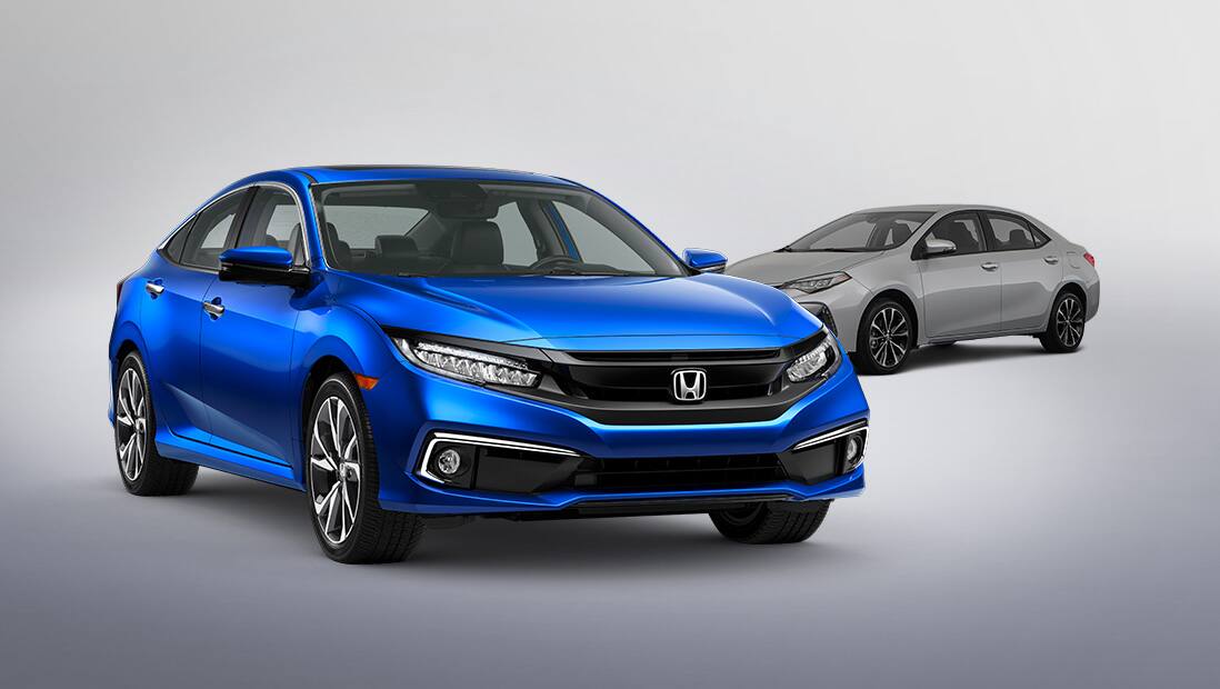 Front 3/4 passenger’s side view of 2019 Honda Civic Touring Sedan in Aegean Blue Metallic with competitor vehicle in background.