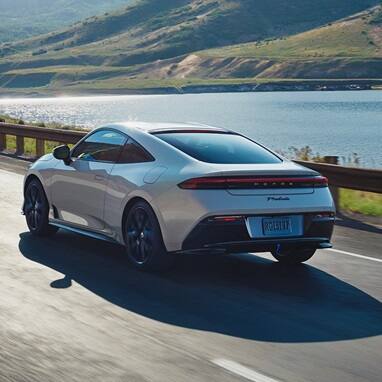 2027 Honda Prelude in Winter Frost Pearl, rear 7/8 view cruising alone the costal highway (exhilarating hybrid coupe).