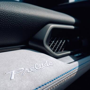 2027 Honda Prelude Bi-Color Stitching and Embroidered Prelude logo on dashboard detail (exhilarating hybrid coupe).